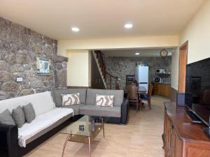 a living room with a couch and a stone wall at Casa da Bia - Gerês in Terras de Bouro
