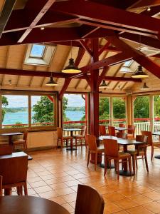 a dining room with tables and chairs and windows at Kyriad Saint-Malo Dinard in La Richardais