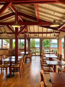 a dining room with tables and chairs and windows at Kyriad Saint-Malo Dinard in La Richardais