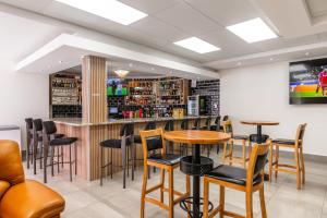 a bar with chairs and a table in a room at Emirates Hotel in Ondangwa