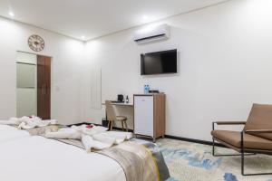 a hotel room with two beds and a television at Emirates Hotel in Ondangwa