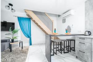 a kitchen with a table and a blue curtain at Słoneczne Domki in Rewal