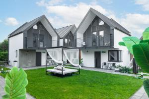 a house with a yard with a swing at Słoneczne Domki in Rewal