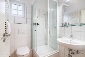 a bathroom with a shower and a sink and a toilet at Gästehaus Daheim in Scharbeutz +36 photos