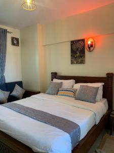 a bedroom with a large white bed in a room at Luxore apartment in Syokimau