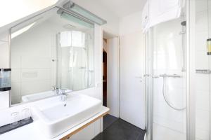 a white bathroom with a sink and a shower at Hotel & Restaurant zum Ritter in Attendorn +21 photos