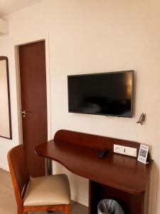 a hotel room with a television on a wall at Kyriad Saint-Malo Dinard in La Richardais