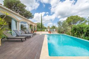 a pool with lounge chairs next to a house at Villa Romana Bonaire in Cielo de Bonaire 