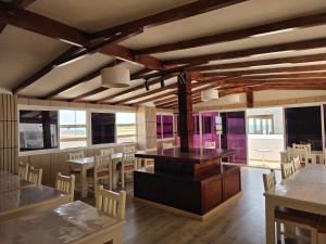 a dining room with tables and chairs and a stove at Boutique Hôtel Albaraka in Dakhla