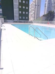 an empty swimming pool in a city with tall buildings at Fleming's Beach in Puebla de Farnals