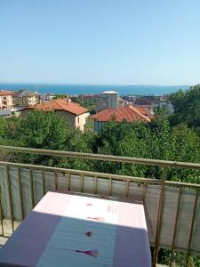 a table on a balcony with a view of a city at Studio A in Sveti Vlas