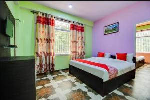 a bedroom with a bed and a flat screen tv at THE PINE STAy in Chail +7 photos