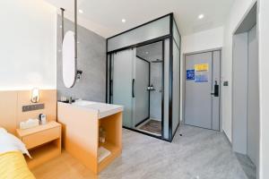 a bathroom with a shower and a sink and a mirror at Yangshuo YeQi Hotel in Yangshuo