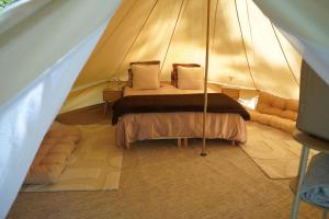 a bedroom with a bed in a tent at Nuit au Ranch Horse Paradise & Jacuzzi in Boutigny-sur-Essonnes