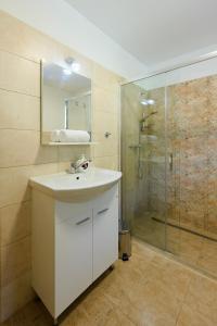 a bathroom with a white sink and a shower at Apartmány Mezivodí in Kyčera +31 photos