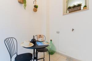a table with a hat and chairs in a room at Arco Suite - Lecce Selection in Lecce
