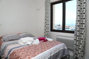 a bedroom with a bed and a window with a view at Beautiful cocoon with shared pool in Le Barcarès in Le Barcarès +3 photos