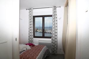 a bedroom with a bed and a window with a view at Beautiful cocoon with shared pool in Le Barcarès in Le Barcarès