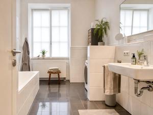 a bathroom with a sink and a tub and a toilet at Schwarzwald Loft Baden-Baden in Baden-Baden +56 photos