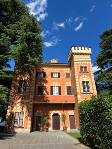 a large brick building with a tree in front of it at La Contessa - Lenno in Lenno