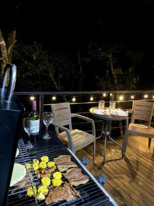 a grill with food and wine on a deck at Natural Glamping Cocorna in Cocorná
