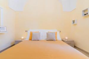 a bedroom with a large bed with orange and white pillows at Arco Suite - Lecce Selection in Lecce
