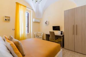 a room with a bed and a desk with a computer at Arco Suite - Lecce Selection in Lecce +32 photos