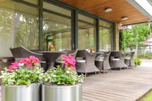 a patio with chairs and flowers in metal pots at Guest House Aštuoni in Palanga