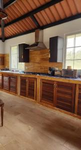 a large kitchen with wooden cabinets in a room at MountainzenEscape in Los Altos de Cerro Azul