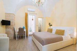 a bedroom with a bed and a table and a television at Arco Suite - Lecce Selection in Lecce