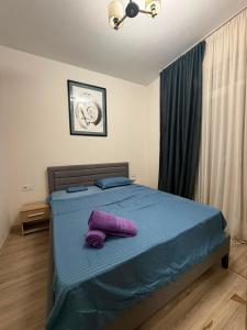 a bedroom with a bed with purple pillows on it at My Sweet Apartment in Tbilisi City