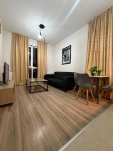 a living room with a black couch and a table at My Sweet Apartment in Tbilisi City