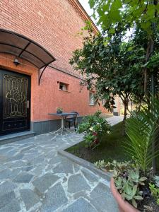 a brick building with a black door and a patio at Guest House Panda in Kutaisi