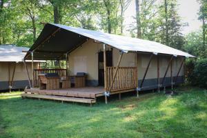 a large tent with a deck in the grass at Park Drentheland in Zorgvlied