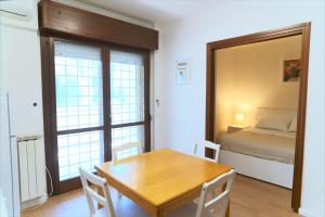 a room with a table and a bed and a window at Appartamento con veranda tra Roma e il mare in Vitinia