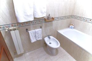 a bathroom with a toilet and a bath tub at Appartamento con veranda tra Roma e il mare in Vitinia +15 photos