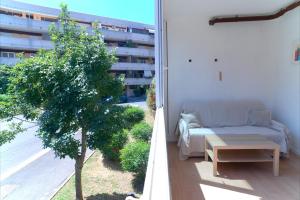 a living room with a couch and a tree on a balcony at Appartamento con veranda tra Roma e il mare in Vitinia