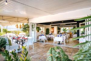 a restaurant with white tables and chairs on a patio at Playa Linda Beach Resort in Palm-Eagle Beach