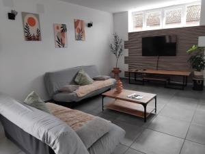 a living room with a couch and a flat screen tv at Le domaine de l'Ebenne in Englefontaine