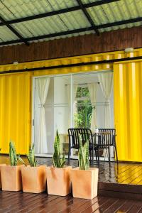 a patio with a table and chairs and yellow walls at Kolibri Containers Boyacá in Guayatá +37 photos