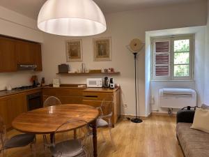 a living room with a table and a kitchen at La Contessa - Lenno in Lenno