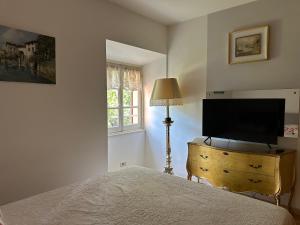 a bedroom with a bed and a television on a dresser at La Contessa - Lenno in Lenno