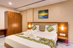 a hotel room with a bed with towels on it at Millennials Hotel in Kammasandra +6 photos
