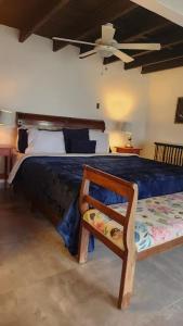 a bedroom with a bed with a chair and a fan at MountainzenEscape in Los Altos de Cerro Azul