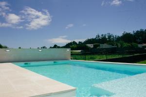 a swimming pool with blue water in a yard at Chalé d'Angra Guest House in Angra do Heroísmo