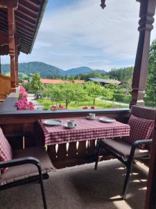 a table and chairs on a porch with a view at Menkenhof in Reit im Winkl