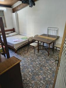 a room with a table and chairs and a bed at Sunset House Lofts Caragua in Caraguatatuba