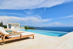 a swimming pool with a view of the ocean at Apiron Luxury Villa in Agía Kyriakí