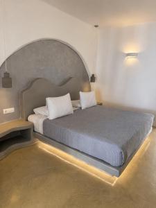 a bedroom with a large bed with a large headboard at La Bellezza Eco Boutique Hotel in Kamari