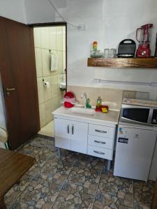 a small kitchen with a sink and a stove at Sunset House Lofts Caragua in Caraguatatuba